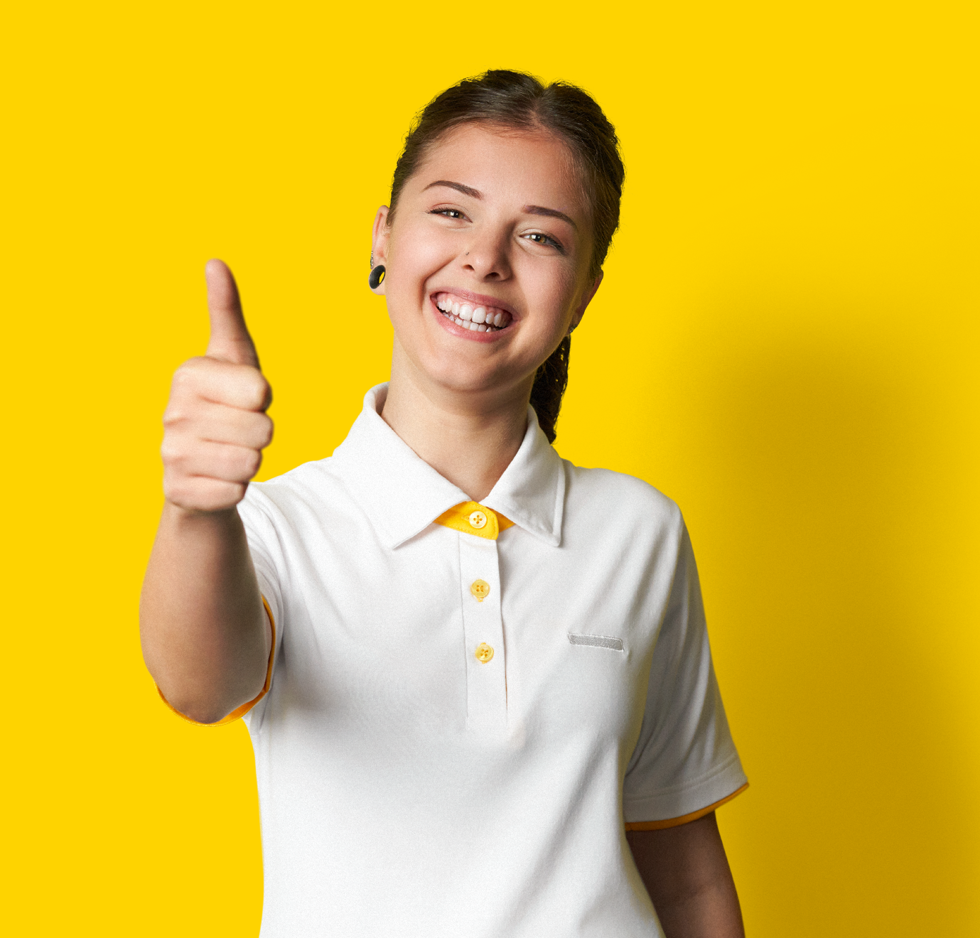 Eine lächelnde Mitarbeiterin, die einen Daumen nach oben zeigt.