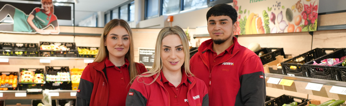 Drei Mitarbeitende stehen im Markt.