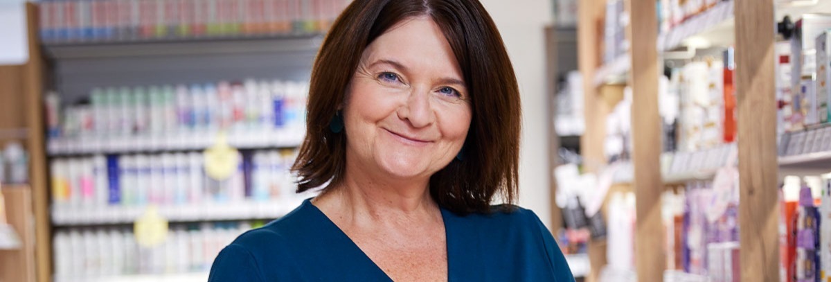 Eine Mitarbeiterin lächelt in die Kamera.