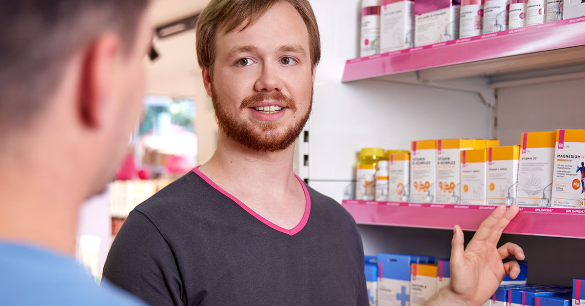 Ein Mitarbeiter zeigt einem Kunden ein Produkt.