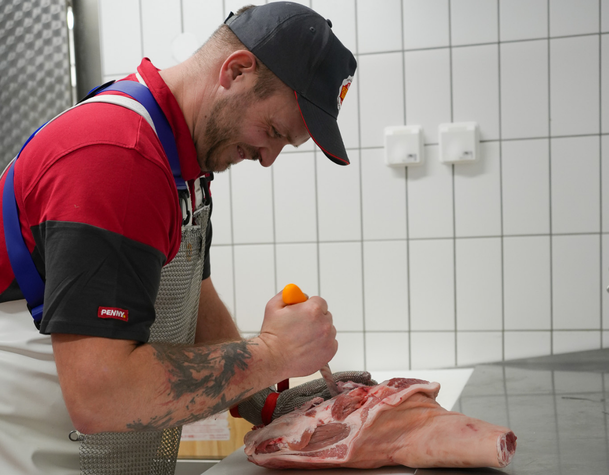 Ein Mitarbeiter bearbeitet Fleisch.