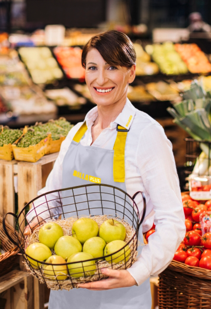 A smiling employee with a fruit basket.