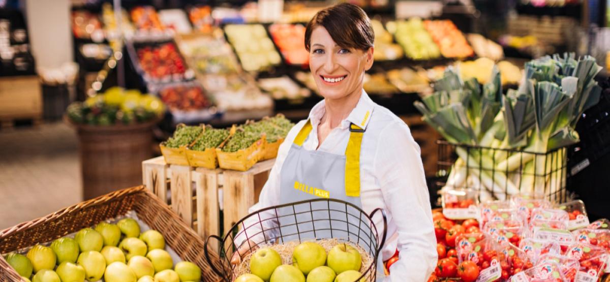 A smiling employee with a fruit basket.